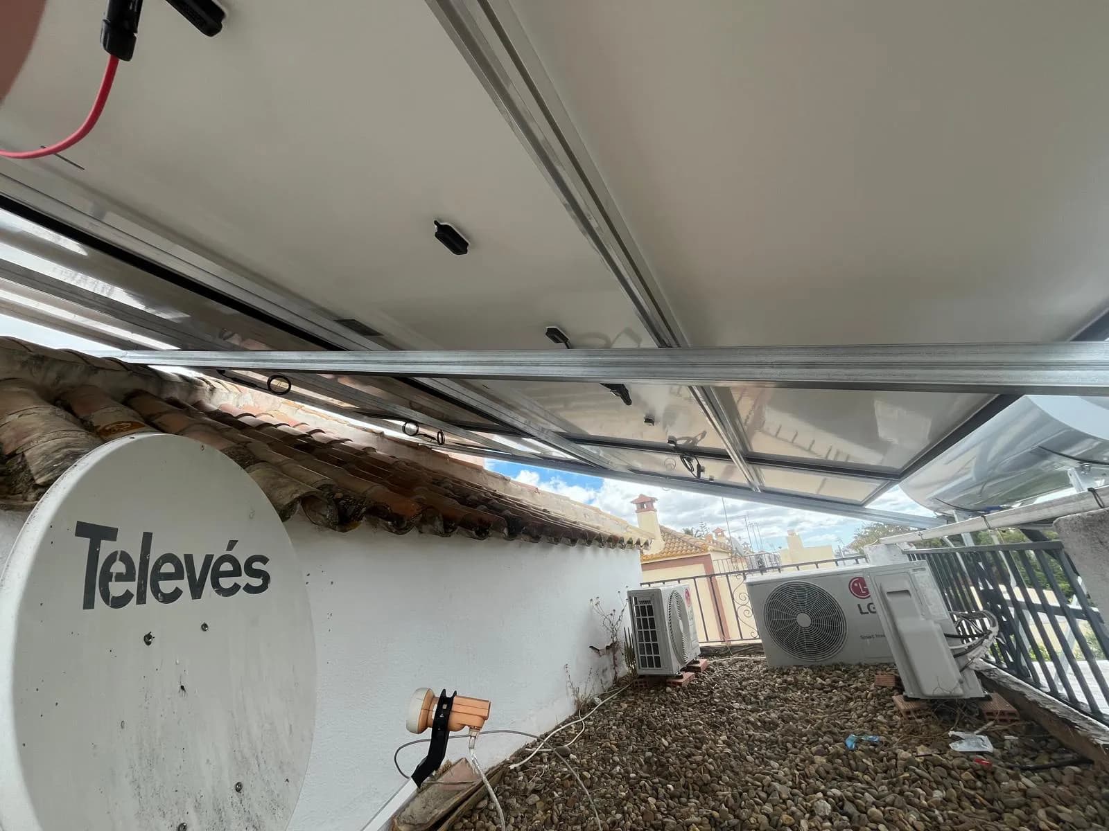 Detalle de estructura inclinada anclada sobre cubierta plana con grava en Sanlúcar la Mayor